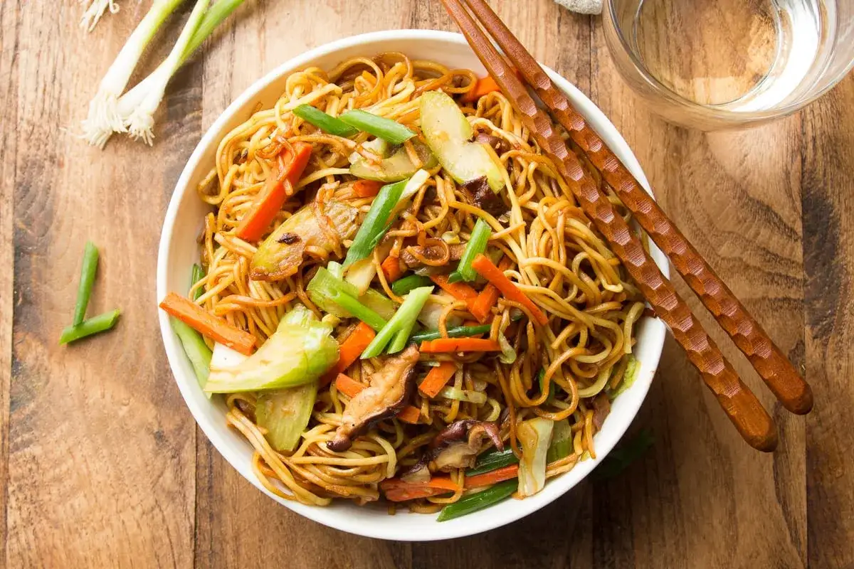 Schüssel mit leckerem Chow Mein, garniert mit Frühlingszwiebeln und Karotten. Perfekt für ein schnelles, asiatisches Abendessen.