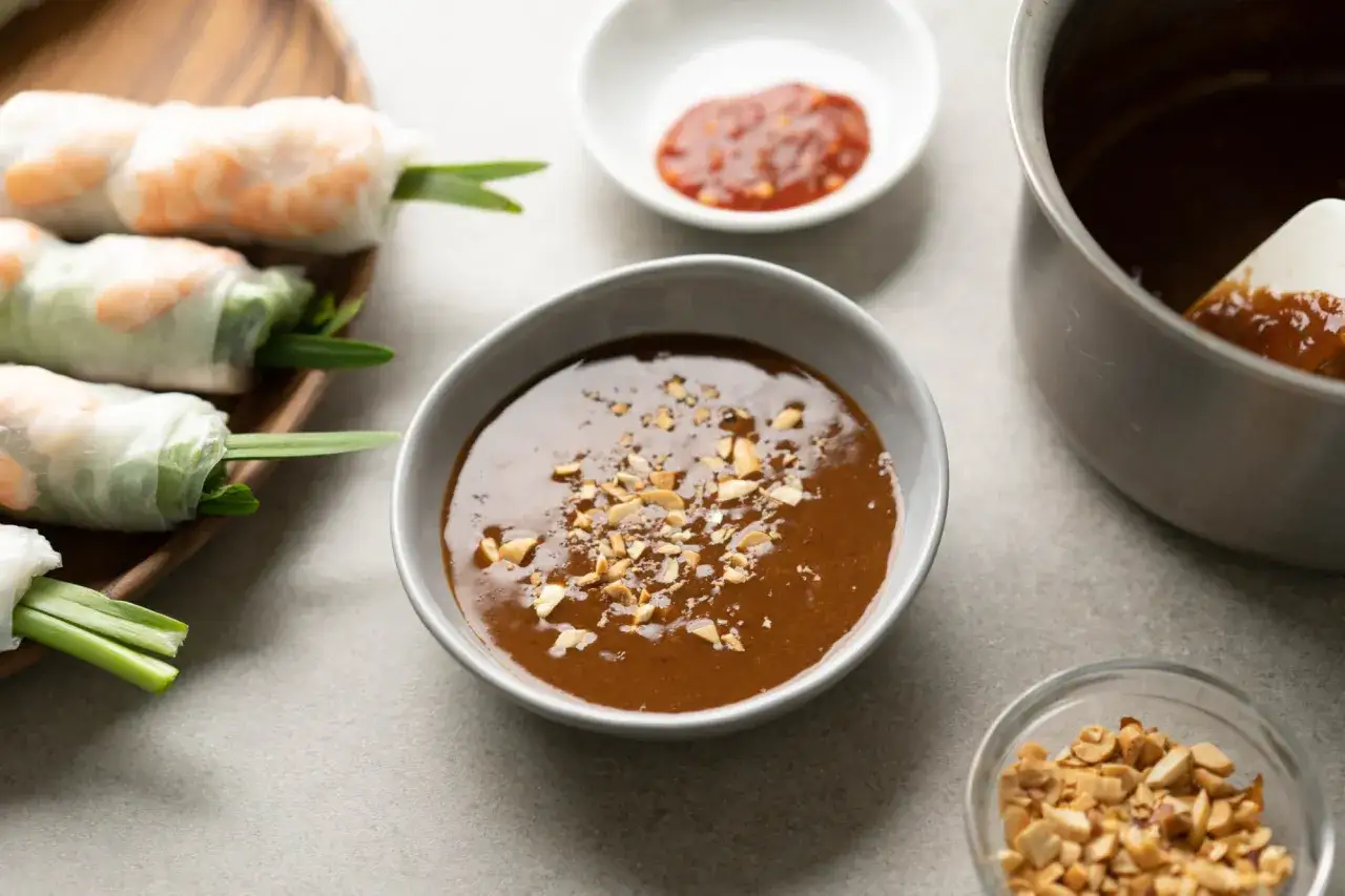 Frische Sommerrollen mit Garnelen und knackigem Gem&uuml;se, serviert mit einer cremigen Hoisin-Sauce und gehackten Erdn&uuml;ssen.