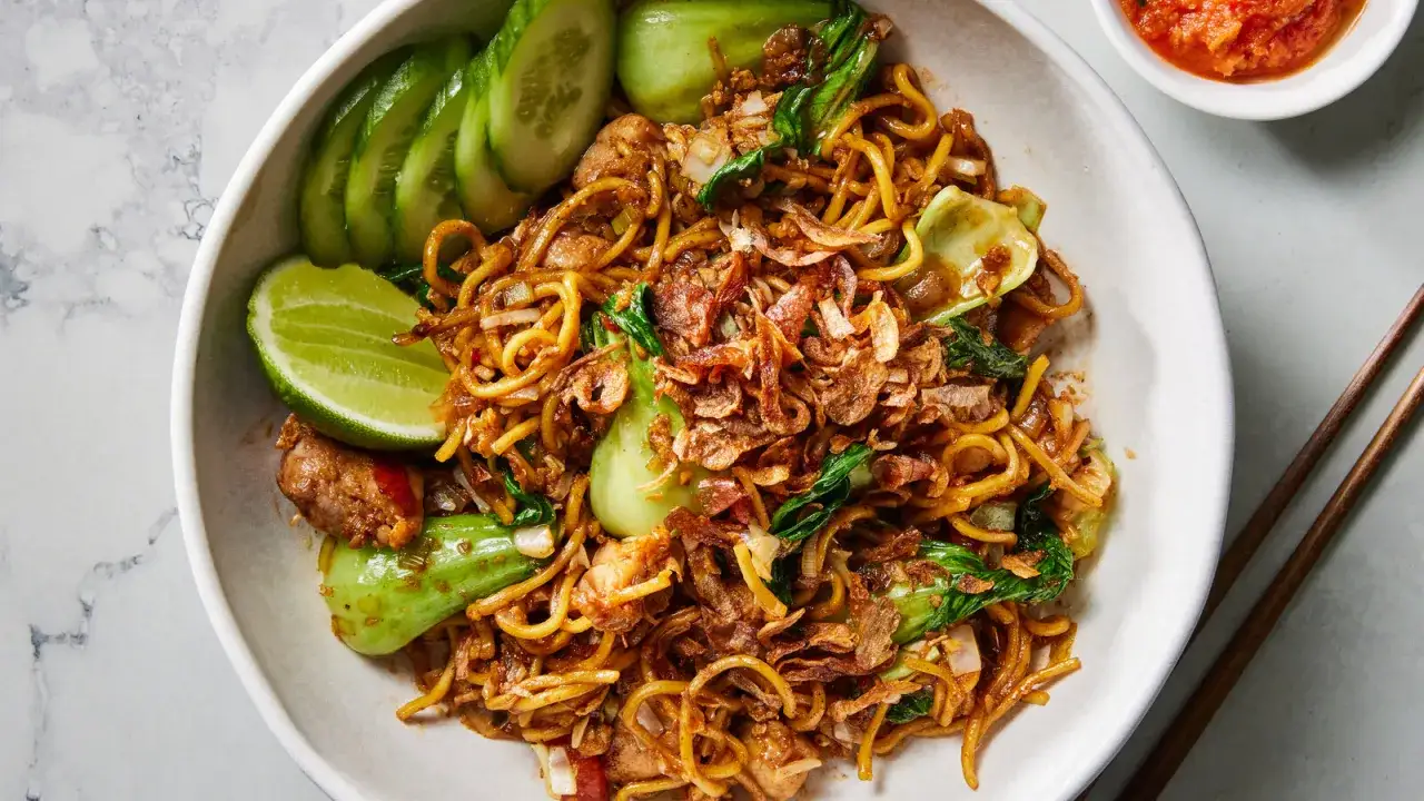 Herzhaftes mie goreng mit knackigem Pak Choi, Gurkenscheiben, Limette und knusprigen R&ouml;stzwiebeln.