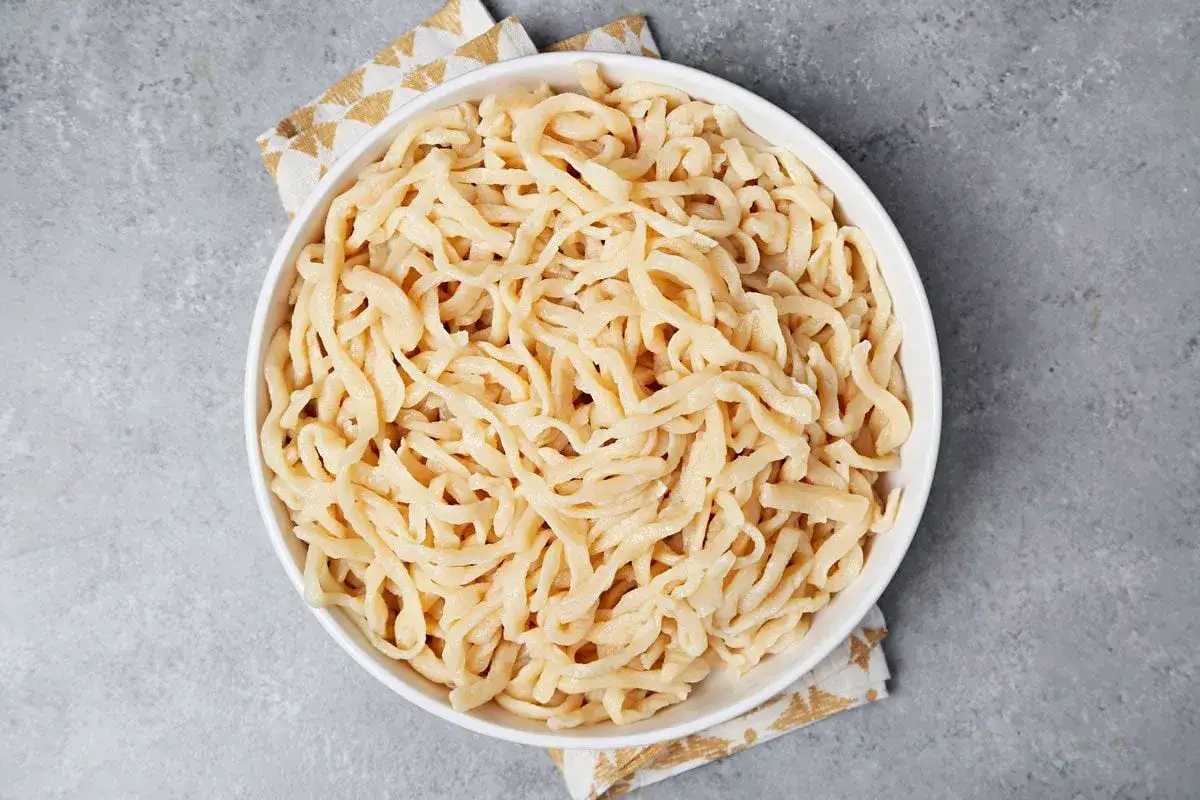 Frisch gekochte Udon Nudeln in einer weißen Schüssel, bereit zum Servieren.