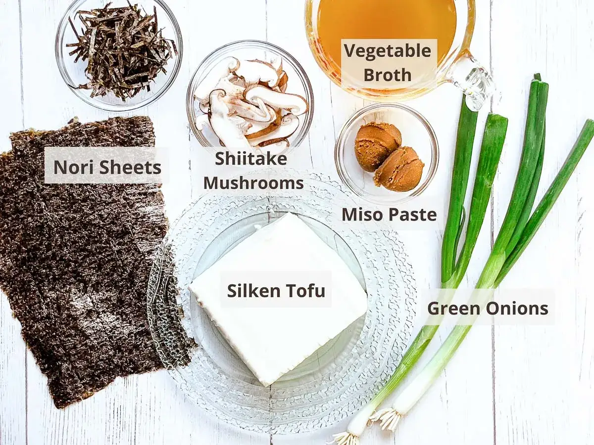 Zutaten f&uuml;r ein einfaches Miso Suppe Rezept: Seidentofu, Shiitake-Pilze, Nori-Bl&auml;tter, Miso-Paste, Fr&uuml;hlingszwiebeln und Gem&uuml;sebr&uuml;he.